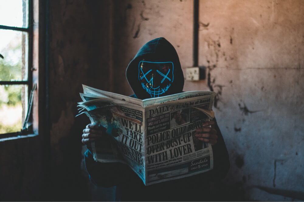 Person in mask read newspaper